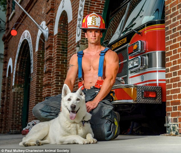 Un bombero con un perro frente a un camión 