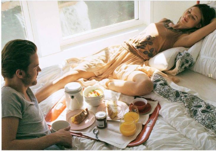 pareja de novios en la cama con el desayuno 