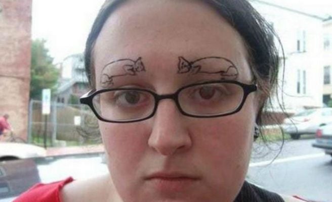 mujer clanca con lentes y con dibujos de gatos en las cejas 