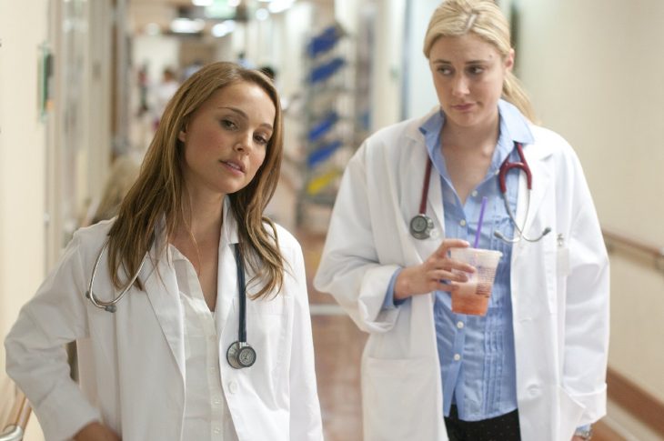 mujeres con batas de doctoras en medio de un pasillo de hospital 