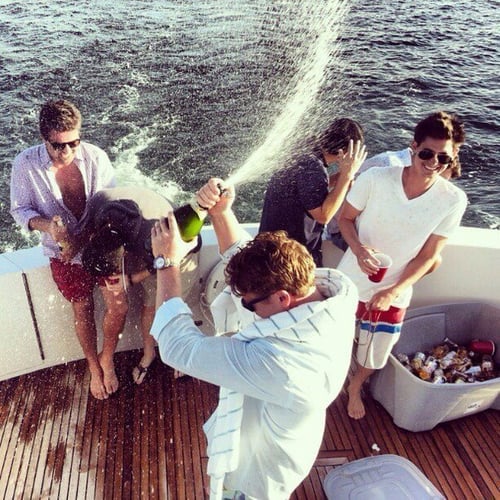 amigos en barco abriendo botella de alcohol 