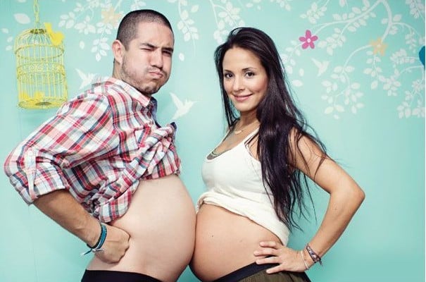 mujer embarazada comparando su panza con la de un hombre 