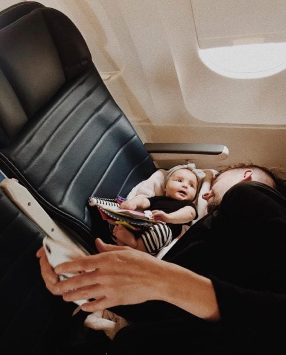 Papá contando cuentos a su bebé en un avión