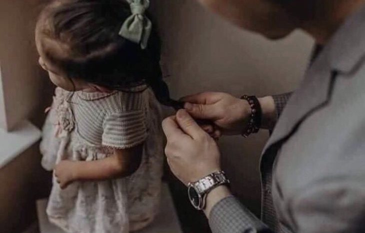 papá haciendo trenzas a su hija pequeña