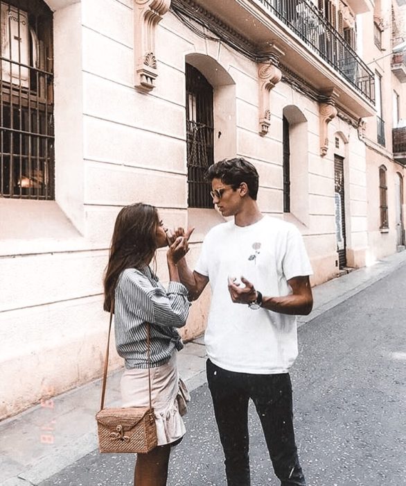 Pareja de novios comiendo algo en la calle