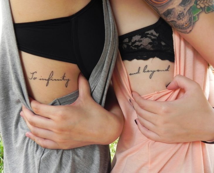 Hermanas con la frase To infinity and beyond tatuada en la costilla 