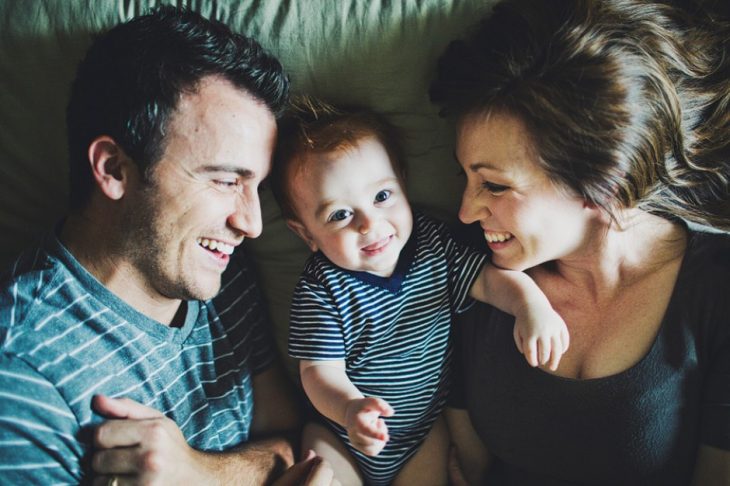 Bebé feliz en medio de sus padres