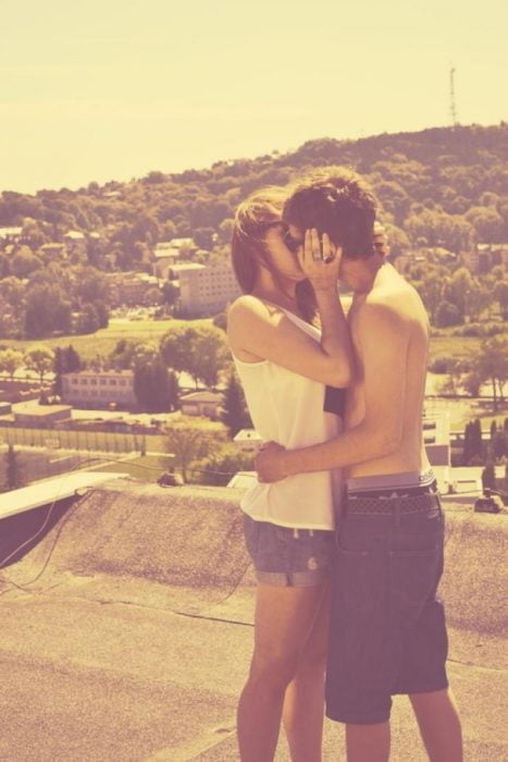Foto de pareja adolescente besándose en un día caluroso 
