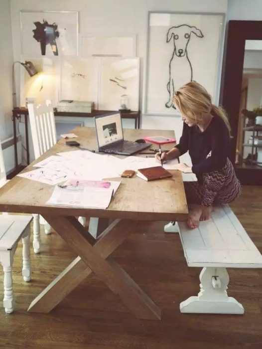 Chica sentada en una mesa haciendo tarea 