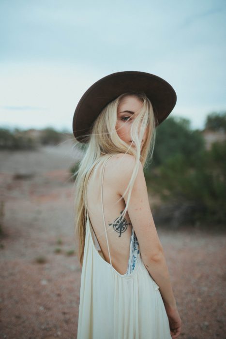 chica con sombrero y tatuaje en un costado 