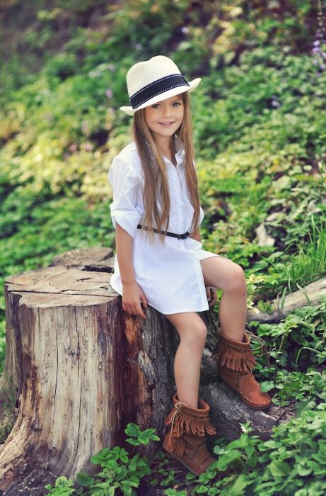 Kristina Pimenova posando para la cámara con un bluson blanco y sombrero