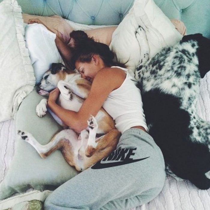 Chica acostada con sus perros 