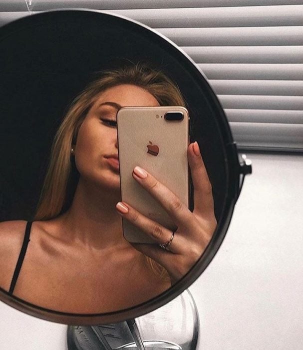 Chica se toma selfie en espejo redondo