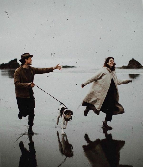 Pareja y perro corren en la playa