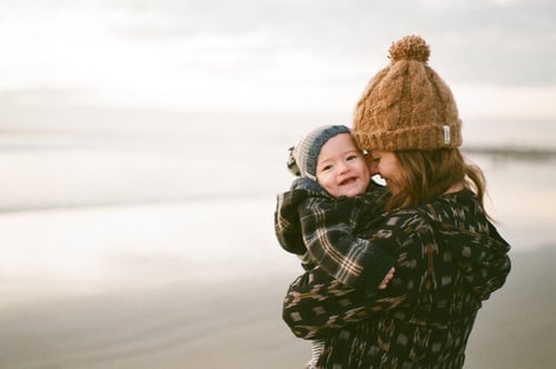 mujer sonriendo abrazando a su bebé 