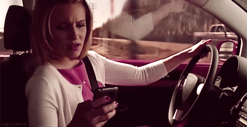 mujer mandando mensajes por celular mientras conduce 