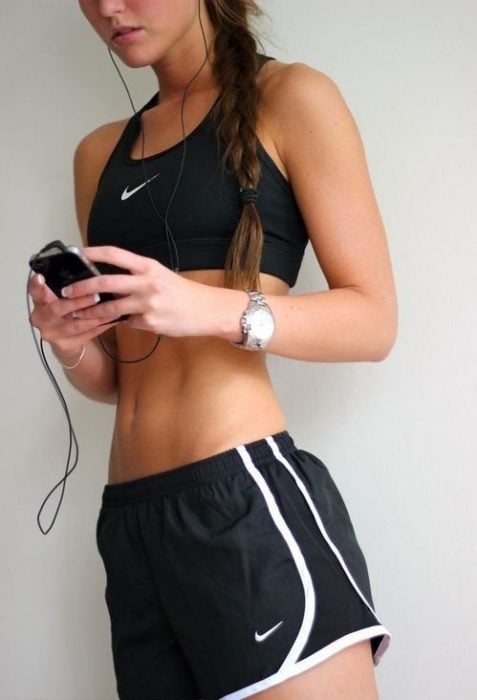 mujer deportiva enviando mensajes por celular 