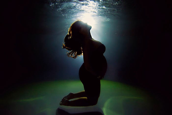 embarazada en contra luz bajo el agua 
