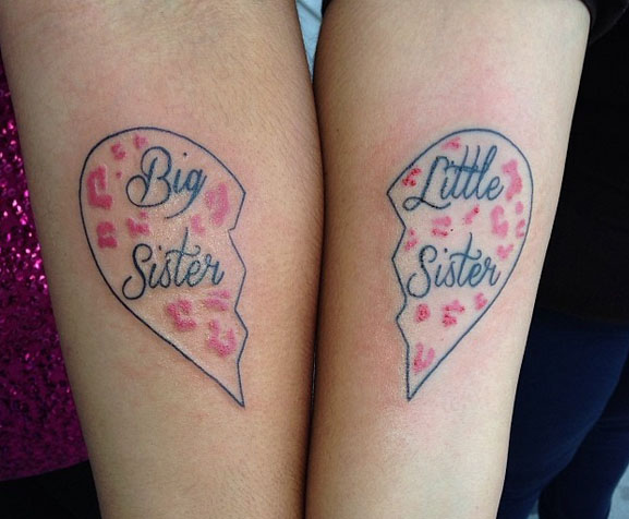 Tatuaje en el brazo de corazón a la mitad con la palabra Big sister y Little sister