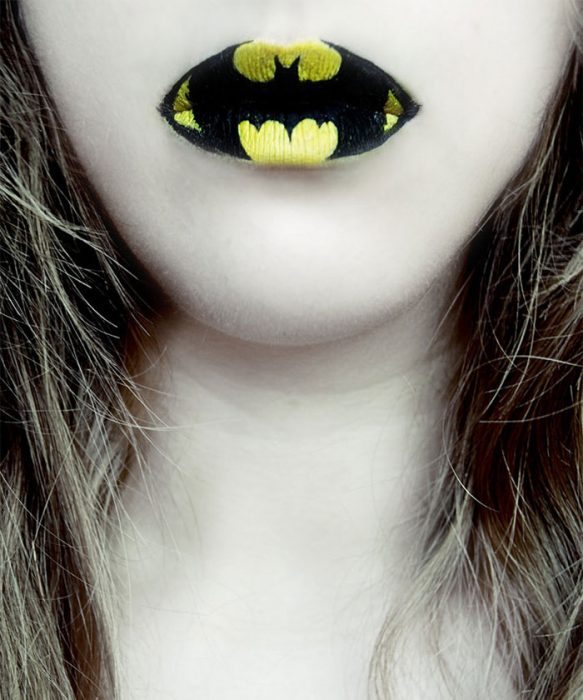 mujer con los labios pintados con la insignia de batman 