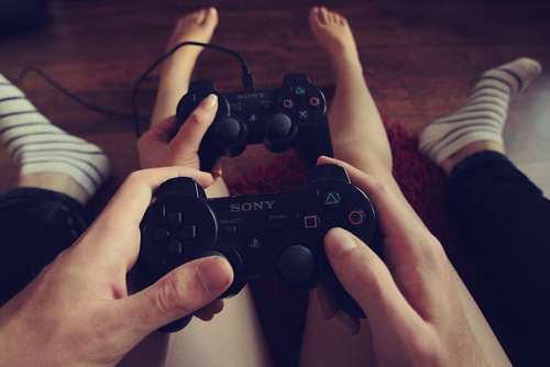 novios sosteniendo controles de vídeojuegos 