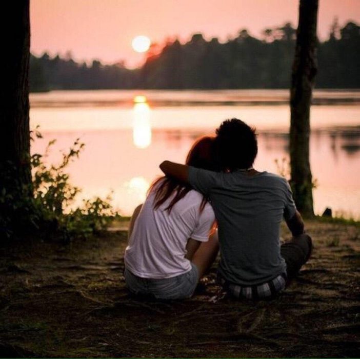 novios sentados en el bosque viendo el amanecer 