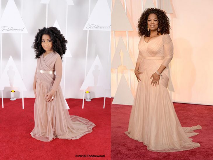 niña con el cabello chino igual que la mujer que esta a su lado paradas en una alfombra roja 