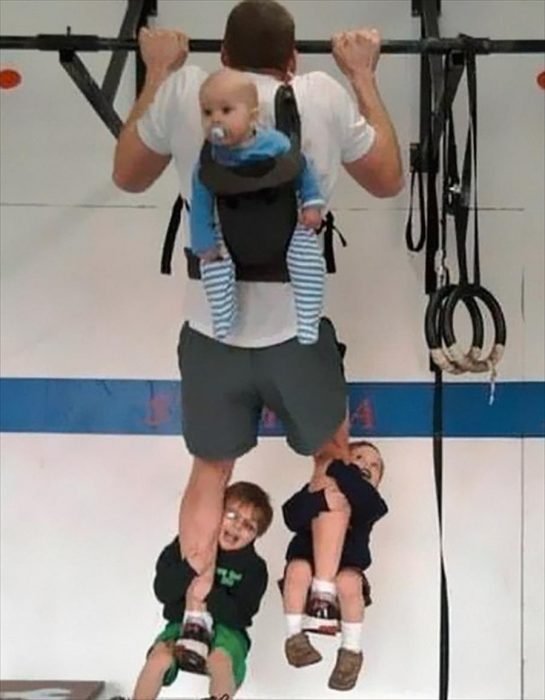 padre haciendo pesas con sus hijos 