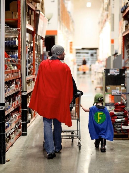 padre e hijo tomados de la mano caminando por un supermercado 