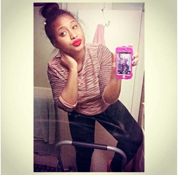 mujer sobre una escalera tomándose fotos en el baño 