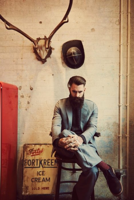 hombre con barba sentado en una silla 