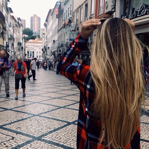 mujer de cabello largo caminando por la calle 