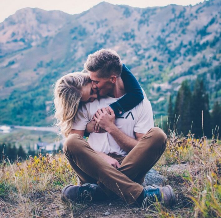 Pareja de novios abrazados felizmente en el suelo 