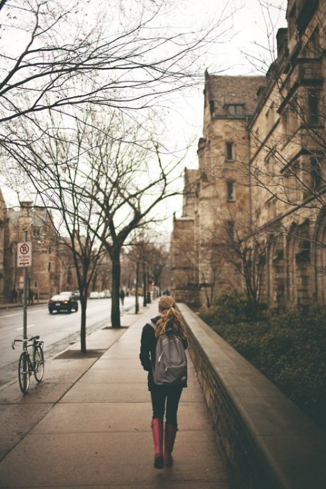 Chica caminando por la calle con una mochila 