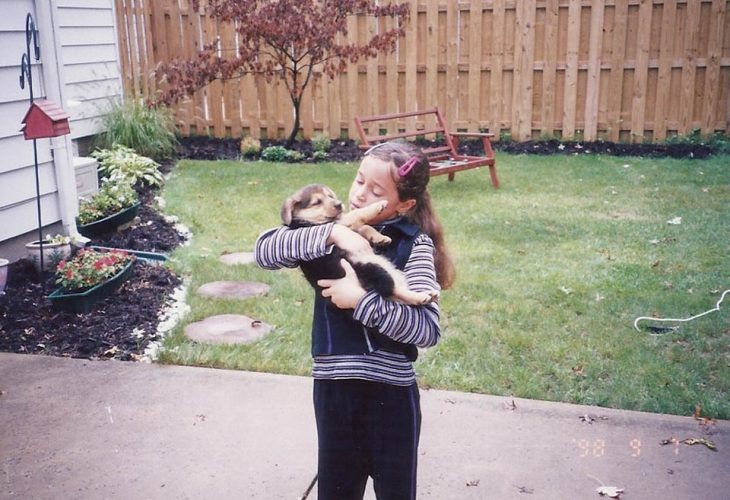 Niña cargando un perro pequeño 