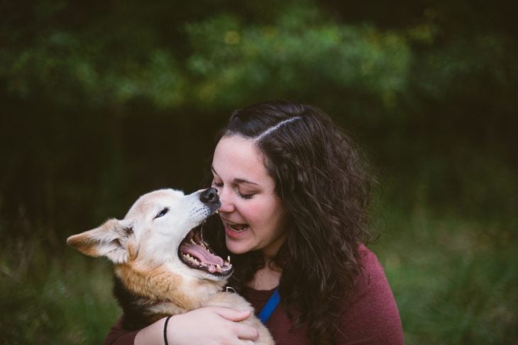 Mujer con un perro mientras bosteza 