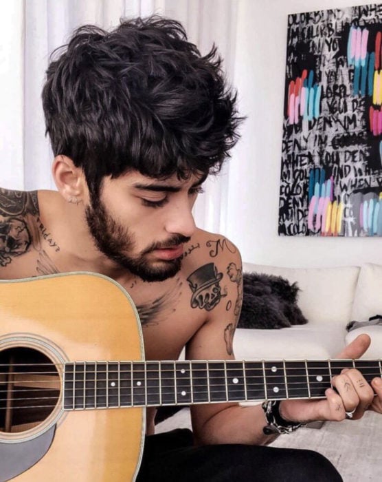 Zayn Malik, hombre con tatuajes tocando la guitarra