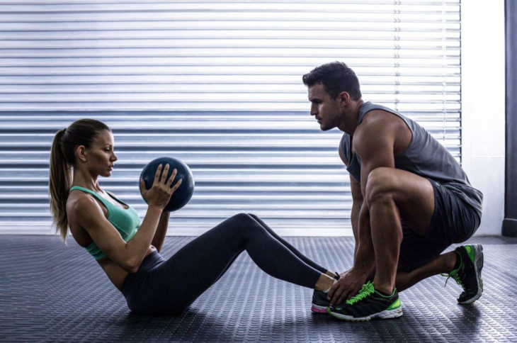 Pareja de novios haciendo ejercicio con pesas 