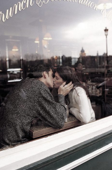 Pareja de novios besándose en un café 