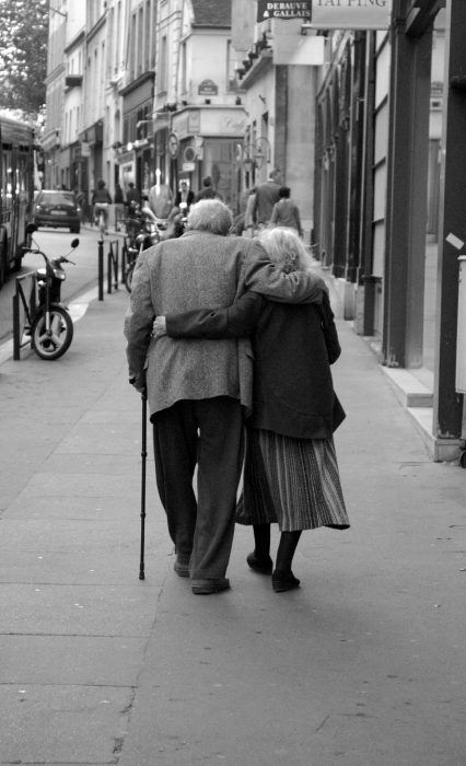 Pareja de abuelitos abrazados caminando por la calle 