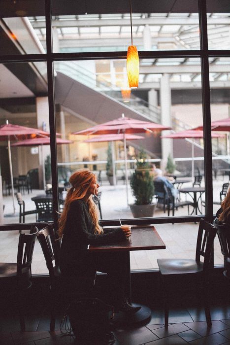 mujer tomando un café sola en una caféteria 