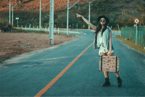 chica pidiendo un aventón en la carretera 