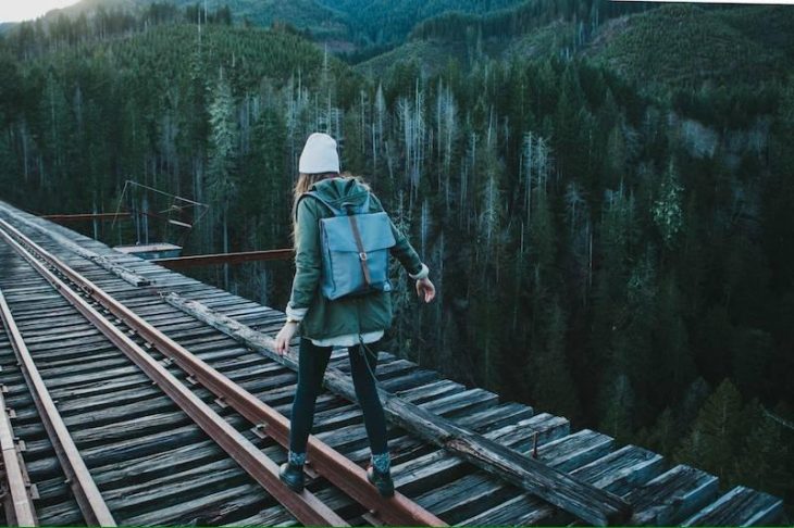 mujer caminando sobre las vías del tren 