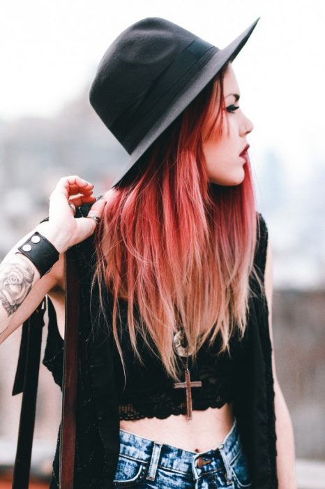 Chica de cabello rojo con tatuajes y perforaciones 