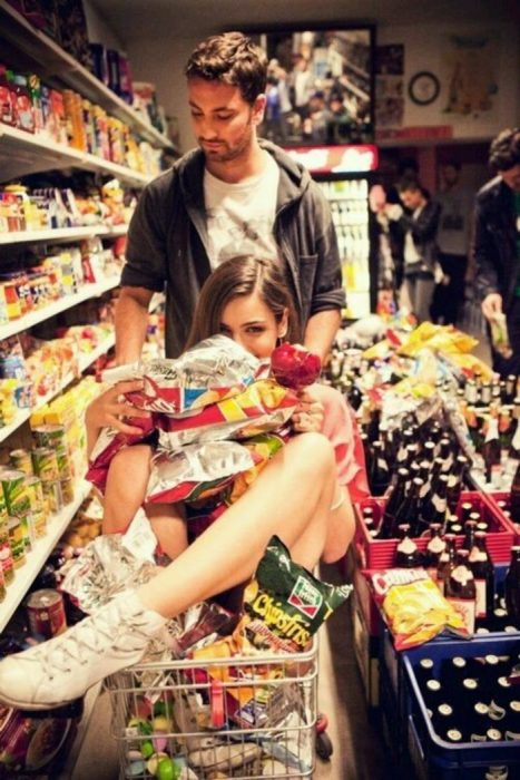 mujer y hombre con el carrito del supermercado lleno de productos 