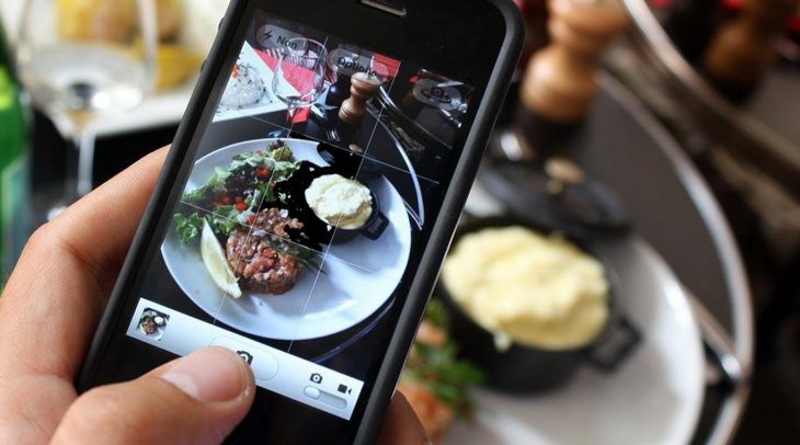 persona fotografiando su comida con el celular 