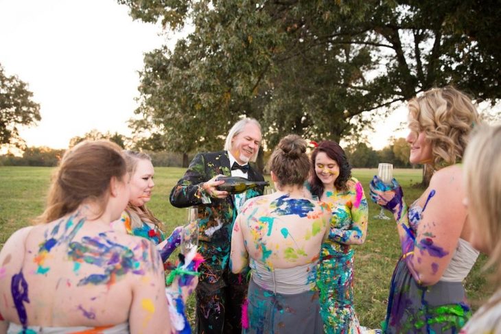 padres de la novia junto a ella y sus damas de honor manchando la ropa de pintura 