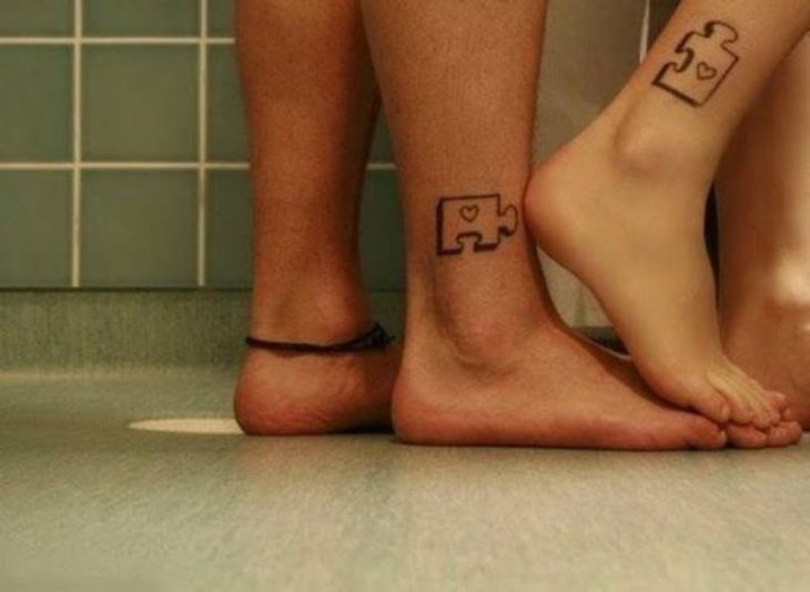 pareja mostrando sus pies con tatuajes en forma de piezas de puzzle 