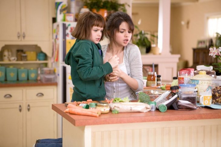 chica y su hermana pequeña cocinando 