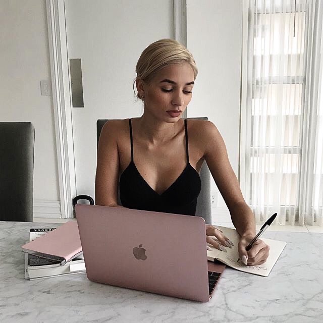 mujer joven trabajando en laptop rosa